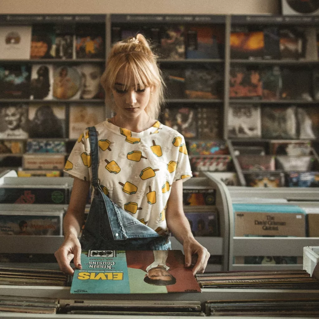 Lady in music shop looking at a record.