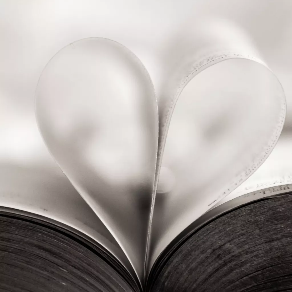 Two pages of a book, folded back to look like a heart shape.
