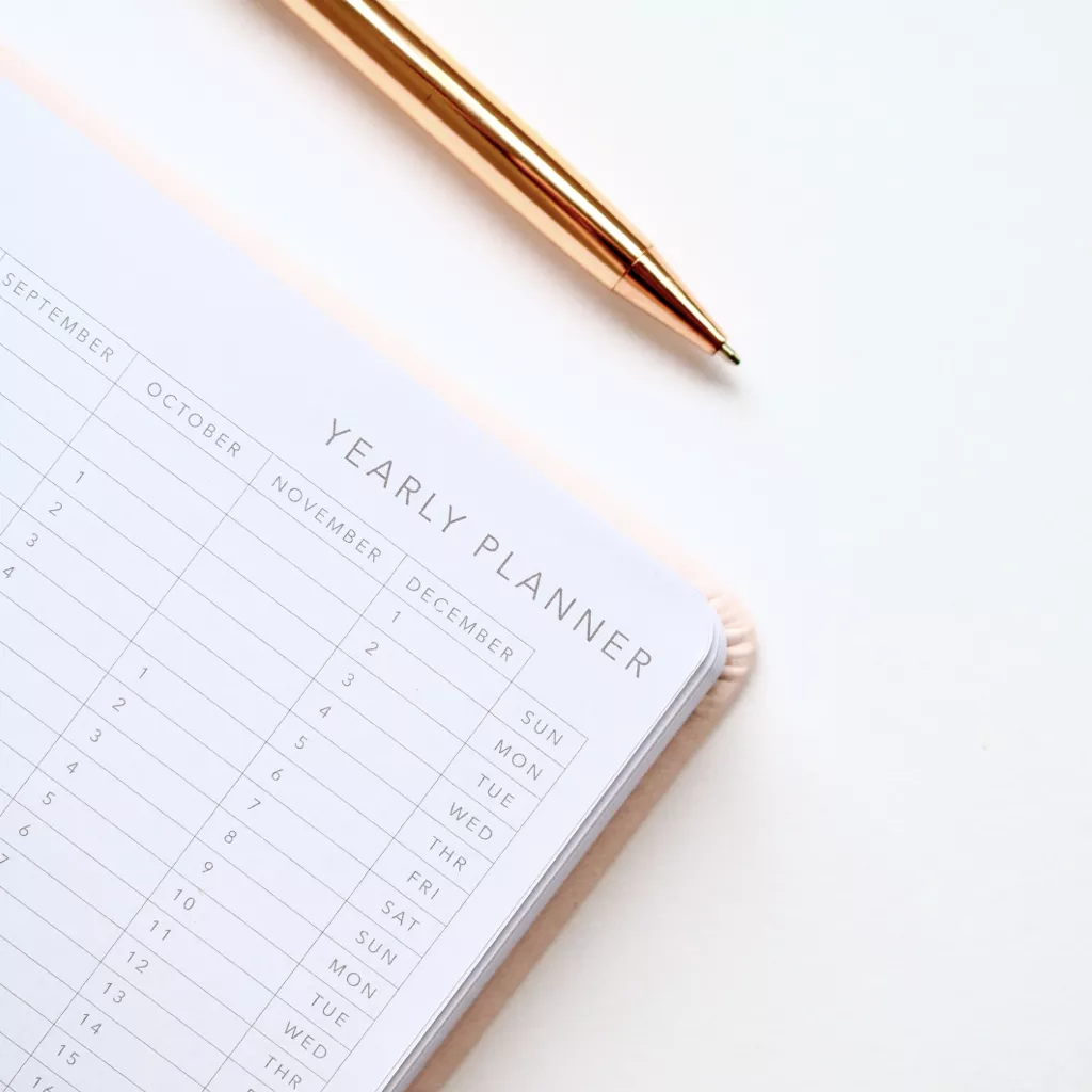 A pen, ready to write in a Year Planner book.