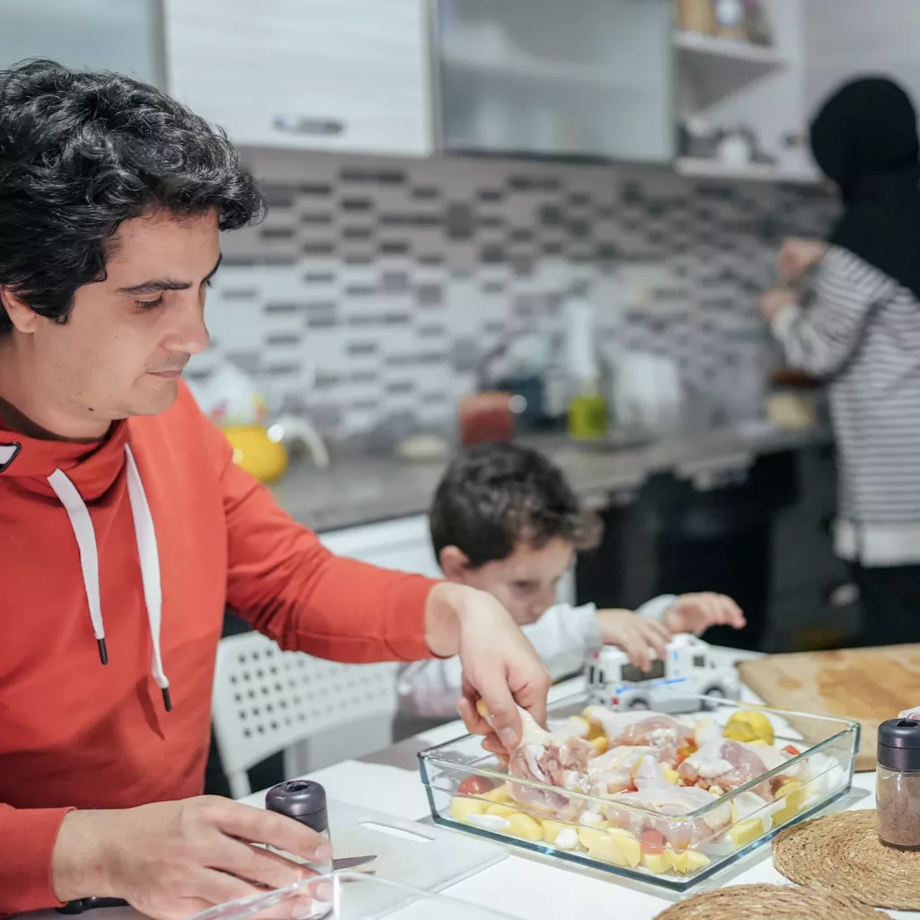 A father serves his son food for dinner.