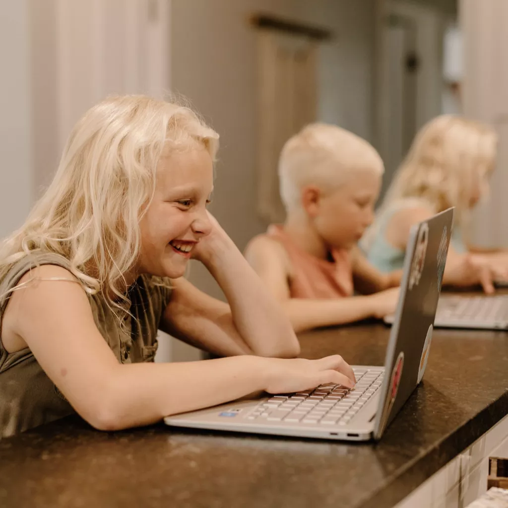 Several children playing on computers.