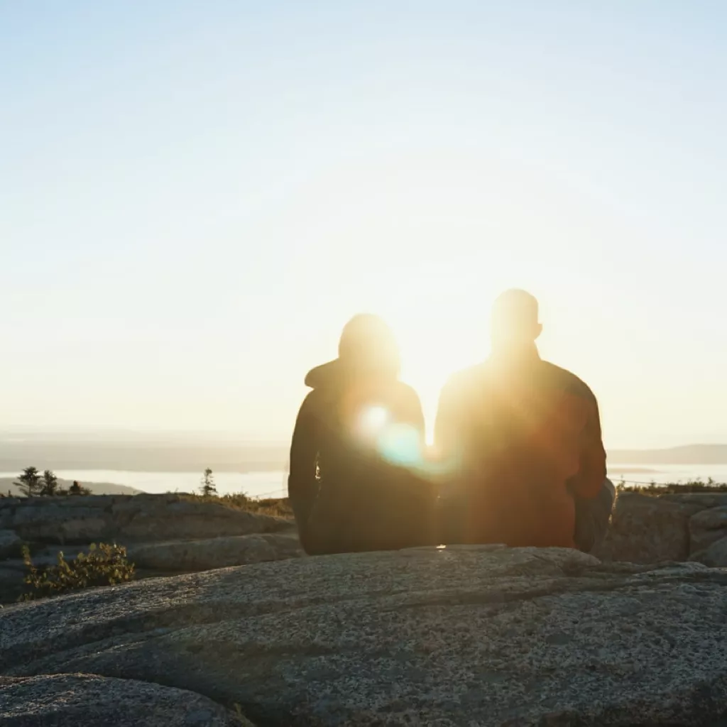 Two friends sat together looking at nature.