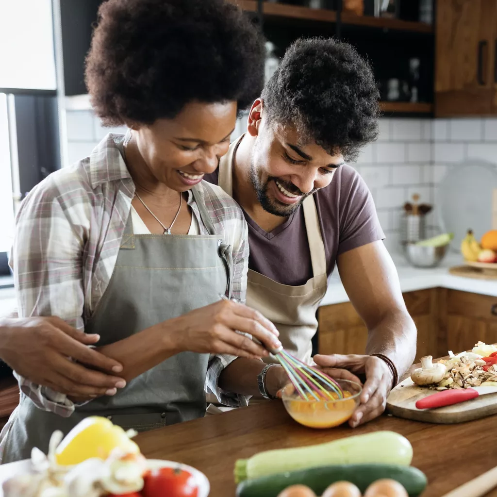 A couple cooking dinner.