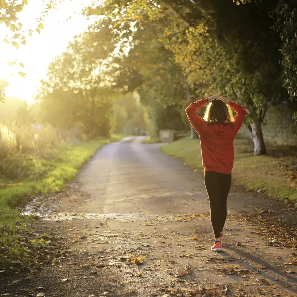 A lady walking along a country road.