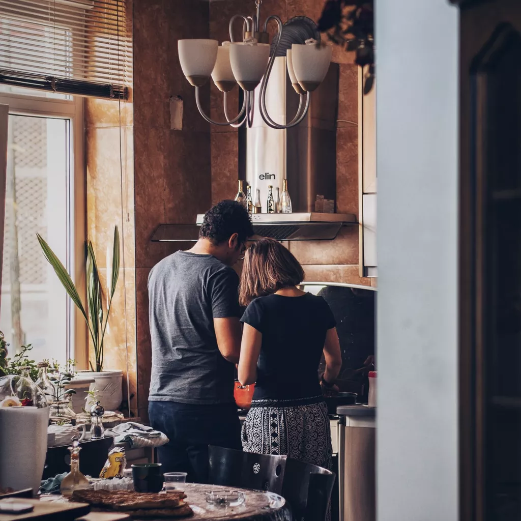 A couple is busy in their kitchen.