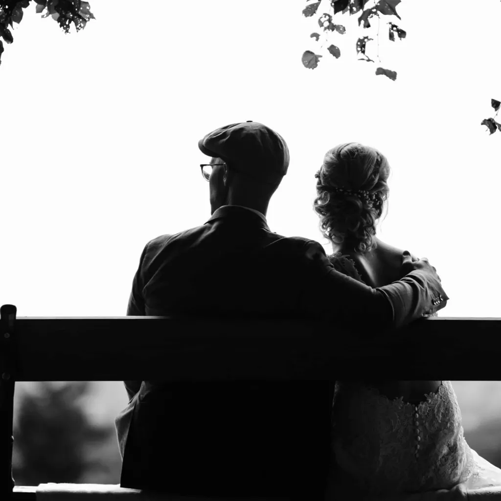 An elderly couple sat on a bench.