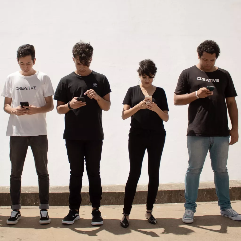 Young people all playing on their phones.