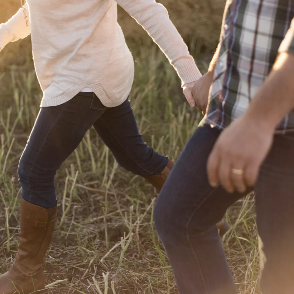 A couple holding hands as they walk.