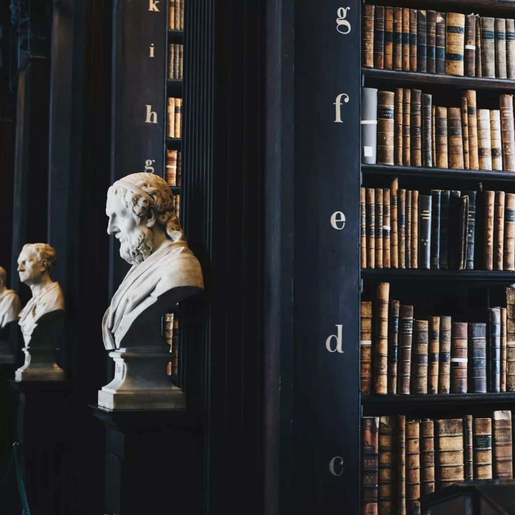 Inside a library showing very old books.