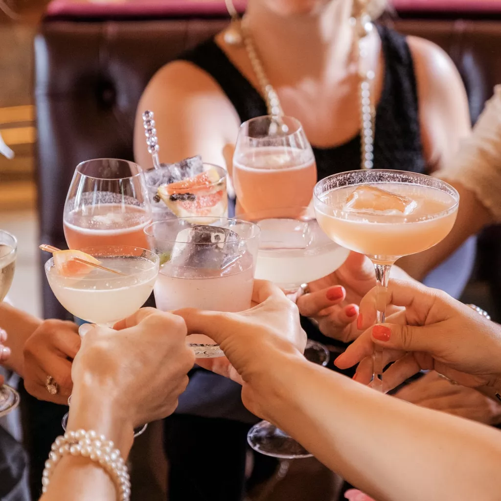 Ladies showing off a range of different cocktails.