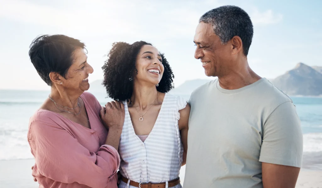 An adult daughter, with her mother and father at the beach.