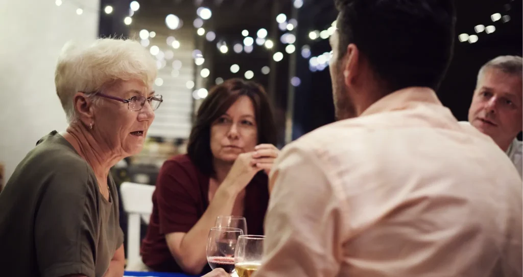 A family group deep in discussion at a dinner table.