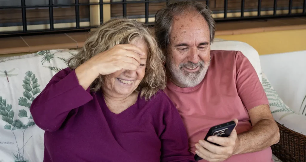 Grandparents playing a game with family using a smartphone.